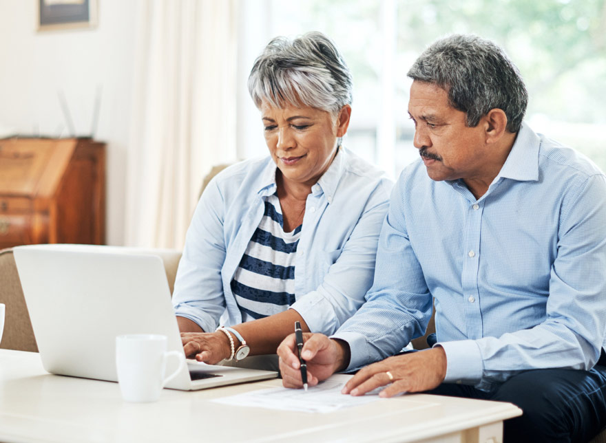 Husband and wife looking at their Southgate Credit Union account on the computer together.